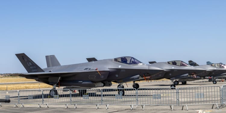 Several F-35s on display at an airfield.