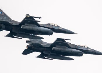 Two F-16s with Greek markings flying next to each other against a white sky.