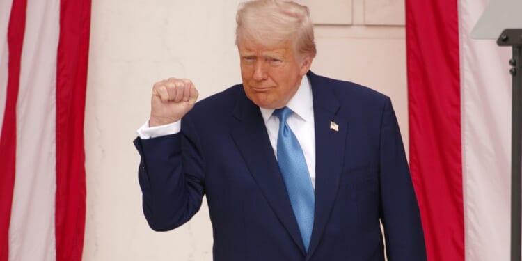 Trump pumps his fist during a Memorial Day ceremony.