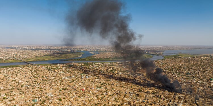 An aerial overview of Omdurman, Sudan, with flames from military clashes during the civil war.