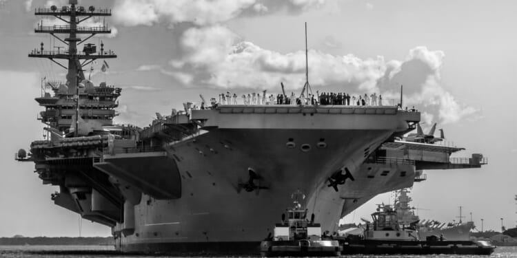 A black-and-white photo of the USS Nimitz aircraft carrier.
