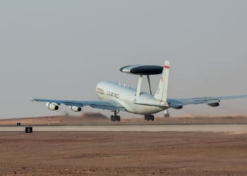 An E-3 AWACS plane taking off from a runway in Saudi Arabia.