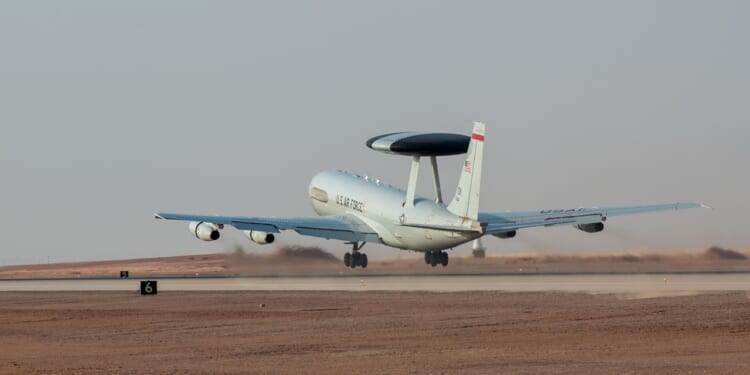 An E-3 AWACS plane taking off from a runway in Saudi Arabia.