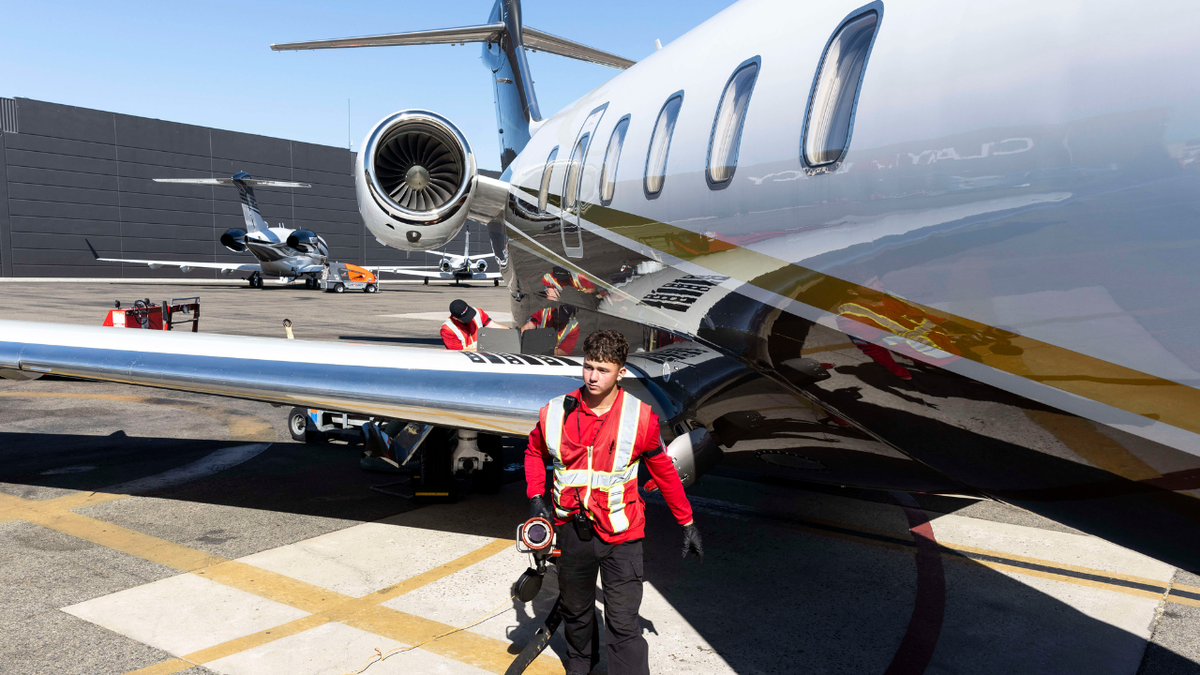 A worker is seen refueling a jet at an airport in California.