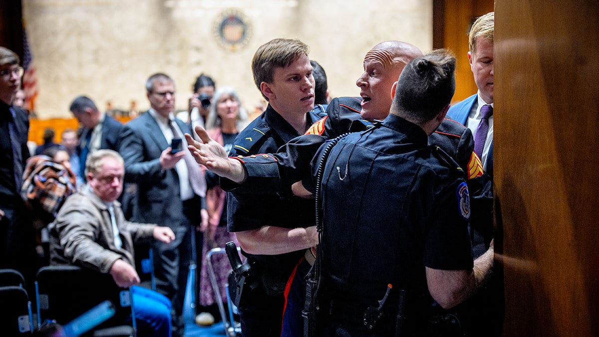 Protester Brian McGinnis being removed by Capitol Police and Sen. Tim Sheehy, R-Montana.