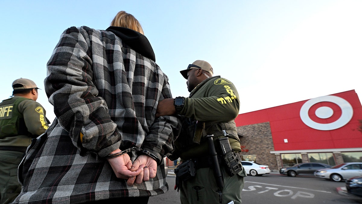 A suspect being taken into custody outside a big-box store in California
