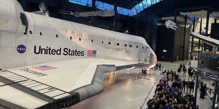 A group of Air Force cadets visiting the Discovery space shuttle.