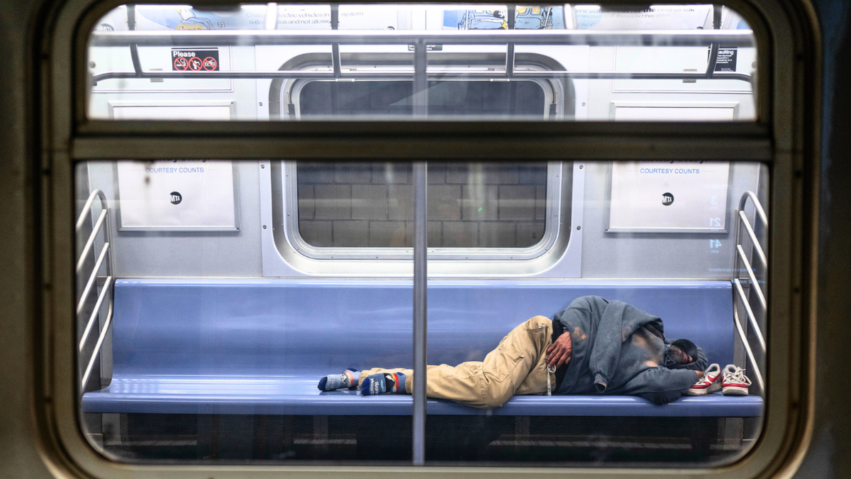 A man is seen sleeping on the E train, one of the subway lines most utilized by homeless New Yorkers for shelter on Monday, April 7, 2025.