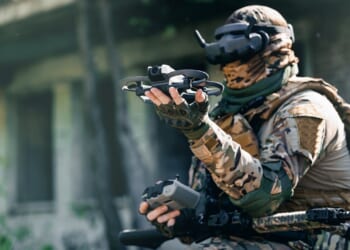 A military FPV drone pilot holding his drone.