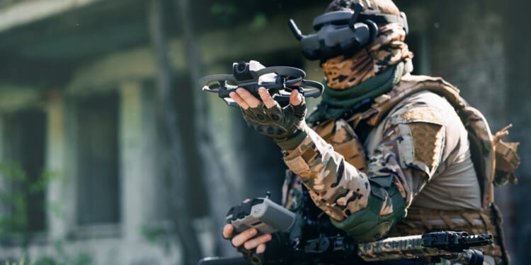 A military FPV drone pilot holding his drone.