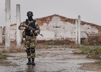 A masked Russian soldier carrying a rifle.