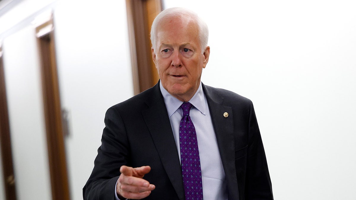 Sen. John Cornyn points in a hallway in the U.S. Capitol.