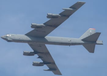 A B-52 Stratofortress in flight against a clear blue sky.