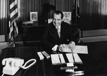 President Richard Nixon sitting at his desk.