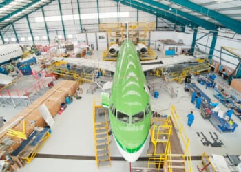 A commercial plane being built on a factory floor.