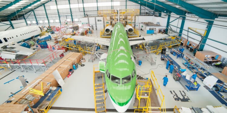 A commercial plane being built on a factory floor.