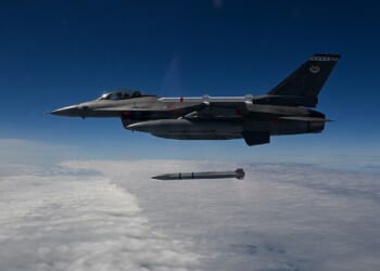 An F-16 Fighting Falcon fighter jet launching a Stand-in Attack Weapon over a cloudy sky.
