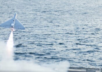A LUCAS drone in flight, launched from an aircraft carrier deck.