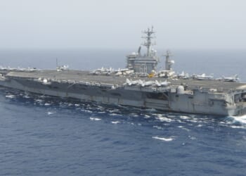 The USS Nimitz aircraft carrier at sea on a foggy day.