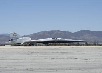 The X-59 experimental plane on the tarmac at an airport.