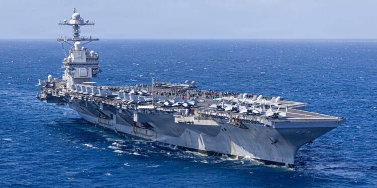 The USS Gerald R. Ford at sea on a clear day.