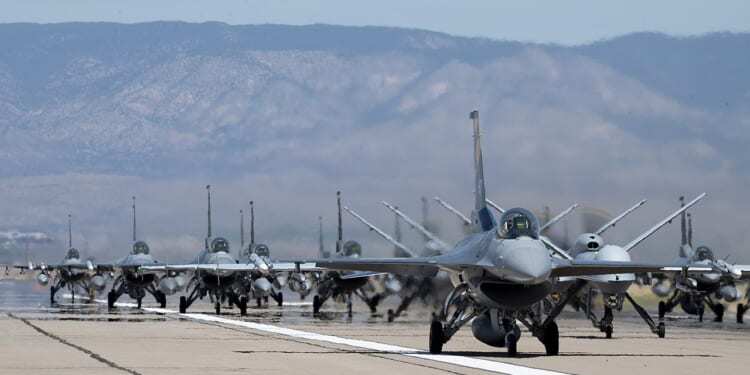 A group of F-16 Fighting Falcon fighter jets on a runway.