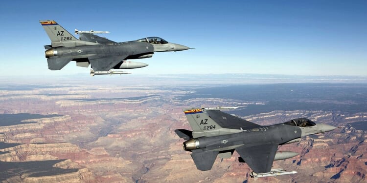Two American F-16 Fighting Falcon fighter jets in flight.