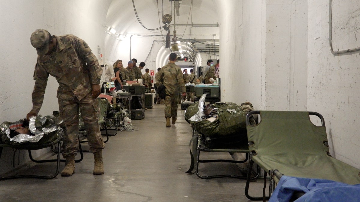 Soldiers treating and working on fake wounded soldiers in a tunnel during training