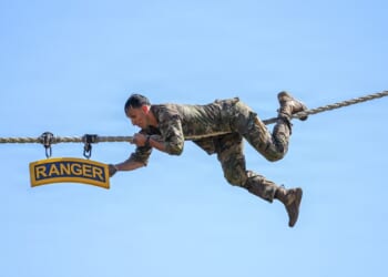 A US Army soldier climbs a rope as part of the Best Ranger Competition.