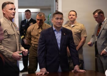 Acting Secretary of the Navy Hung Cao surrounded by military officers.