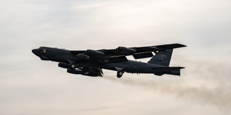 A B-52 Stratofortress in flight against a cloudy sky.