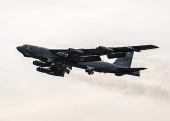 A B-52 Stratofortress in flight against a gray sky.