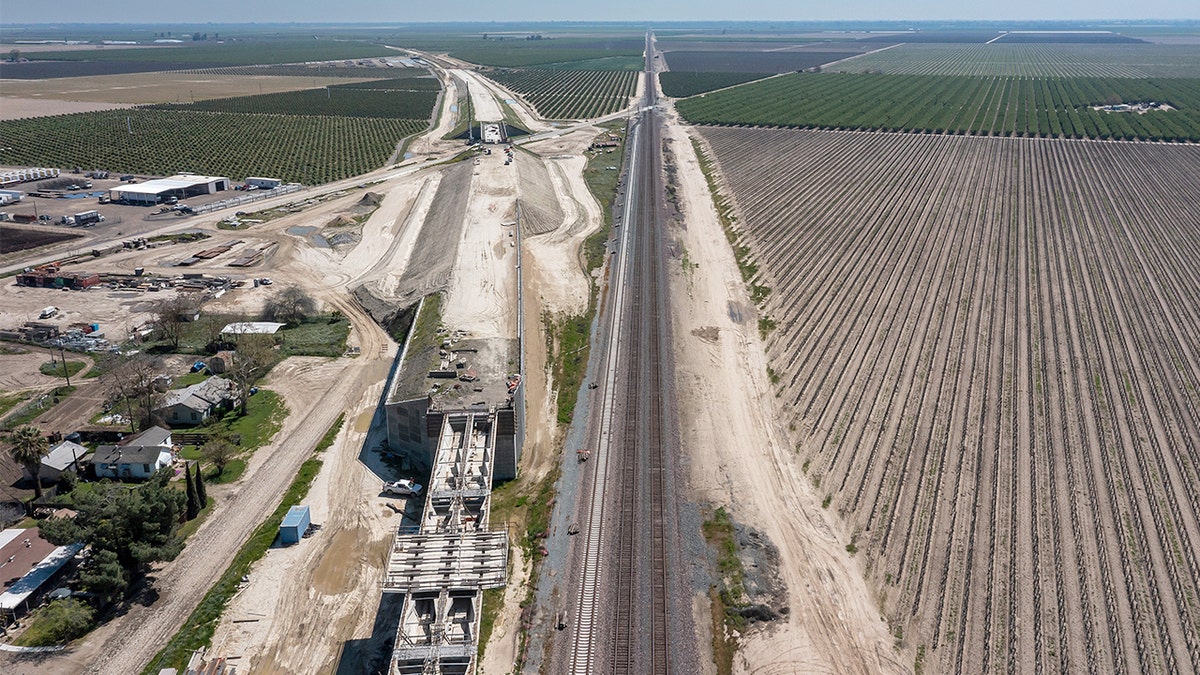 Construction crews and heavy machinery working on elevated rail structure in Fresno County California