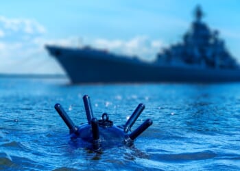A naval mine in front of a ship in the background.