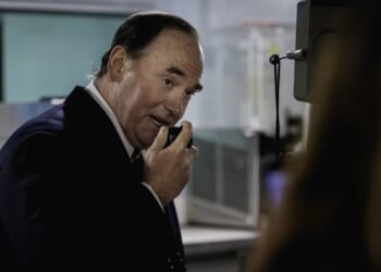 Secretary of the Navy John Phelan holds up an intercom device.