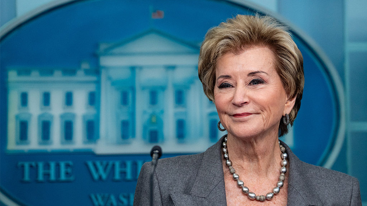 Linda McMahon speaking at a podium in an indoor setting