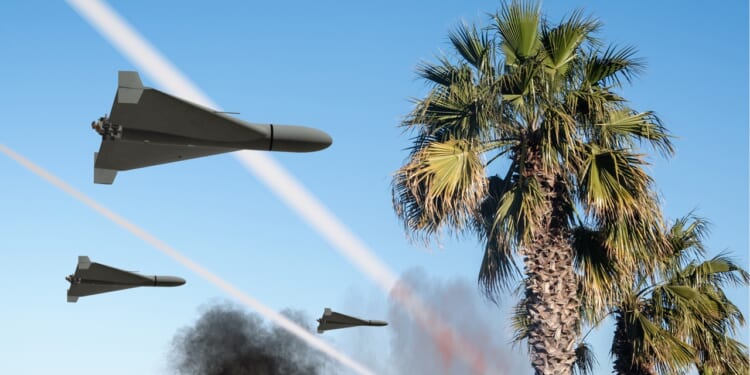 A group of Iranian Shahed kamikaze drones seen over palm trees.