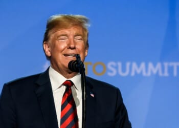 President Donald Trump smiles as he gives a speech at the NATO summit in 2018.