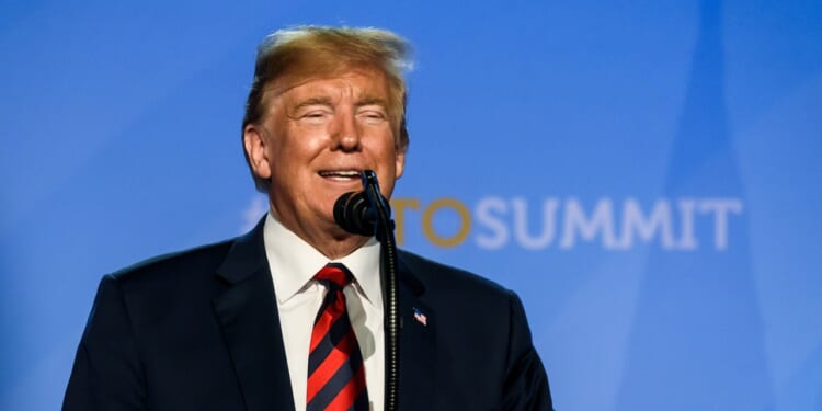 President Donald Trump smiles as he gives a speech at the NATO summit in 2018.
