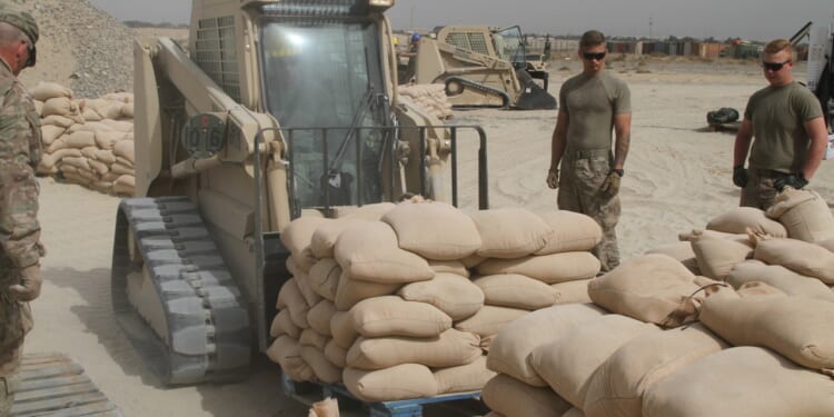 A vehicle moves sandbags at Camp Arifjan in Kuwait.