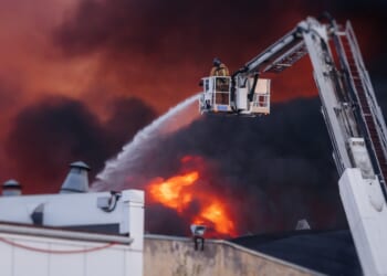 Firefighters putting out a fire in a large building.