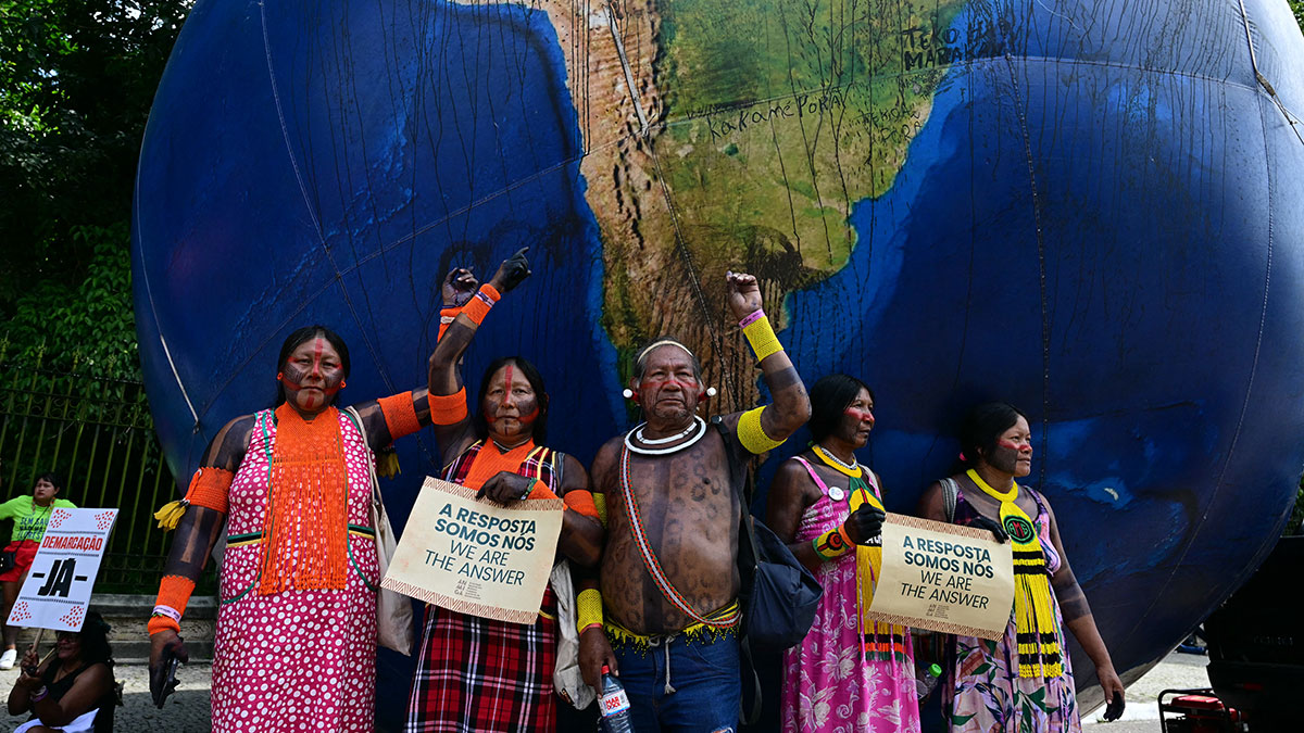 Indigenous people posing next to a giant inflatable globe at last November’s COP30 UN climate-change conference in Belém, Brazil