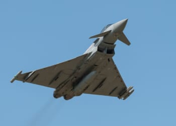 A Eurofighter Typhoon in flight against a blue sky.