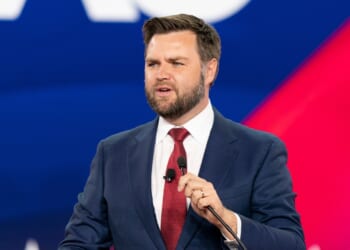JD Vance giving a speech, with the CPAC logo in the background.